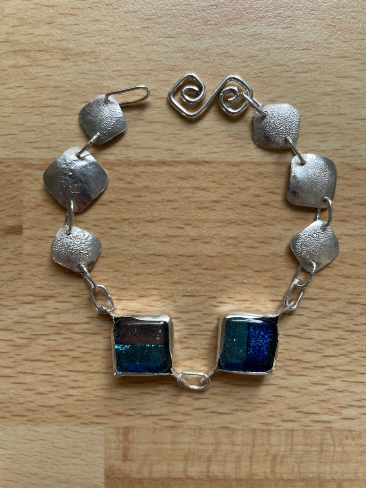 Bracelet using fused glass cabochons set in sterling silver bezels and using reticulation on sheet silver.