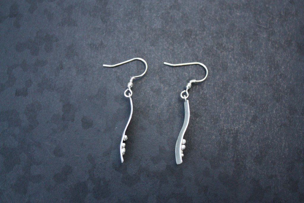 Side view of earrings showing curvature applied and profile of the granules.