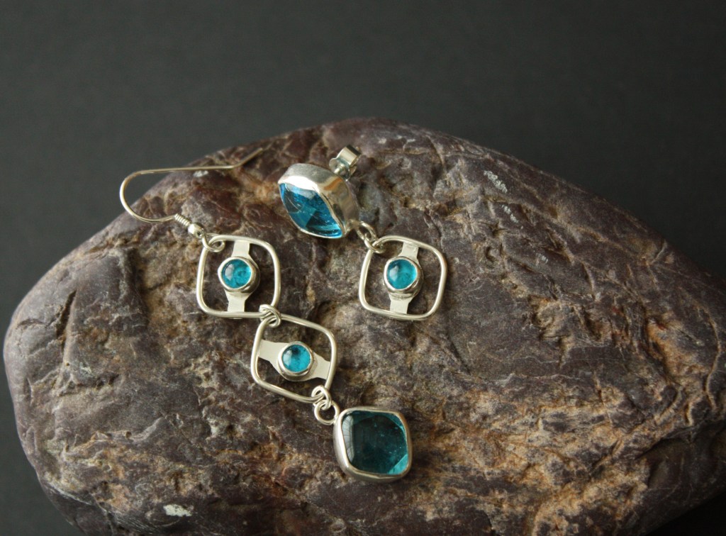 Asymmetric earrings using fused glass cabochons set in silver.