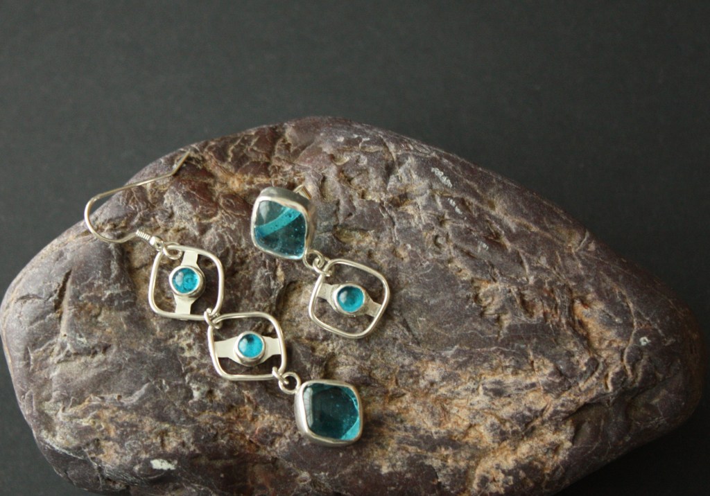 Asymmetric earrings using fused glass cabochons set in silver.