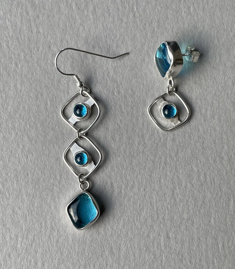 Asymmetric earrings using fused glass cabochons set in silver.