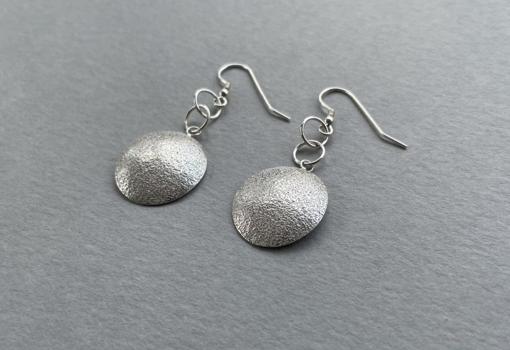 Textured domed earrings made from sterling silver.