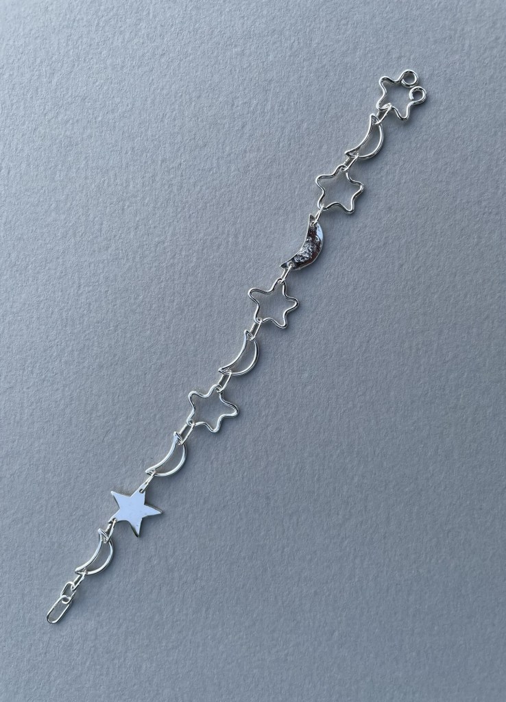 Moon and star bracelet made from a combination of solid and wire shapes.