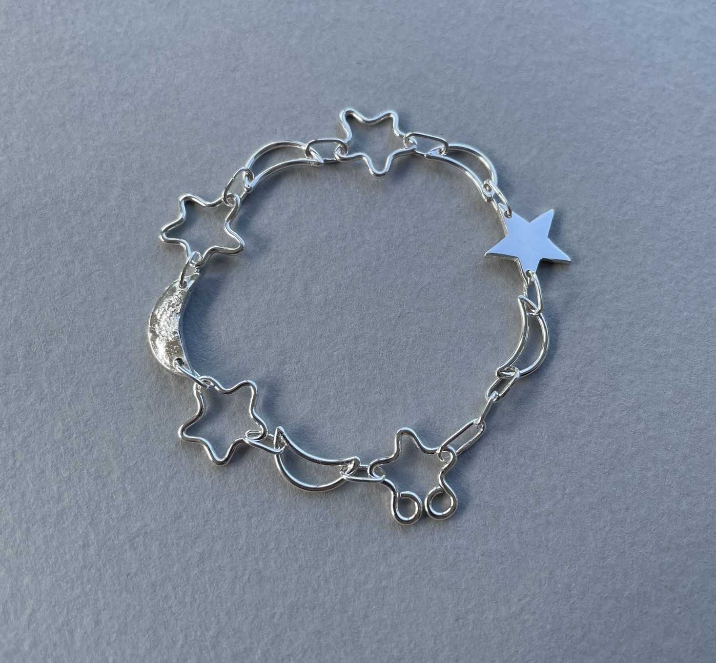 Moon and star bracelet made from a combination of solid and wire shapes.