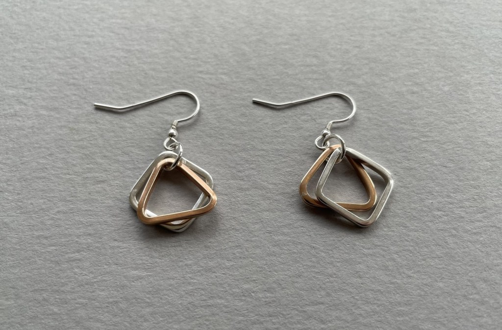 Earrings in silver and bronze using square and triangular shapes.