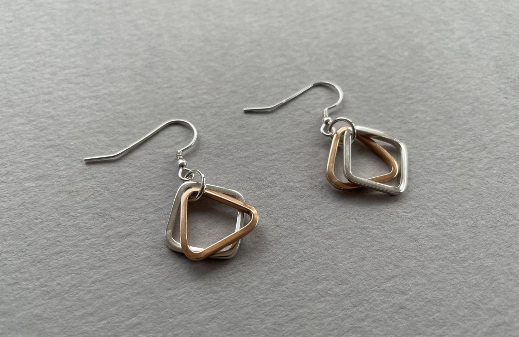 Earrings in silver and bronze using square and triangular shapes.